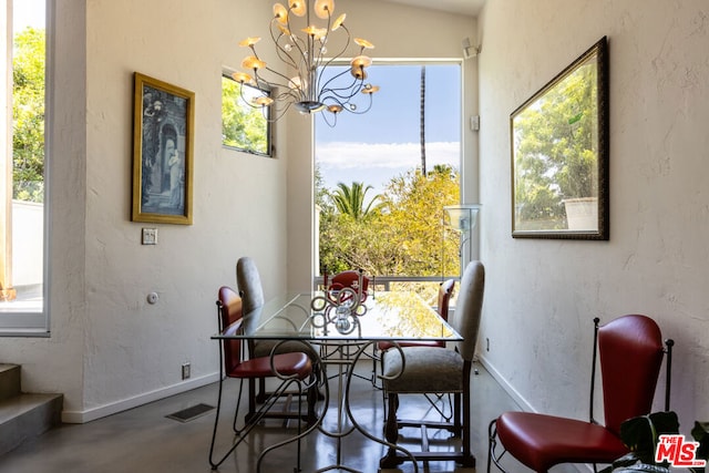 dining area with concrete flooring and a chandelier