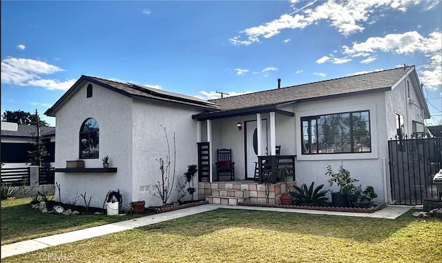 view of front of home with a front yard, fence, and stucco siding