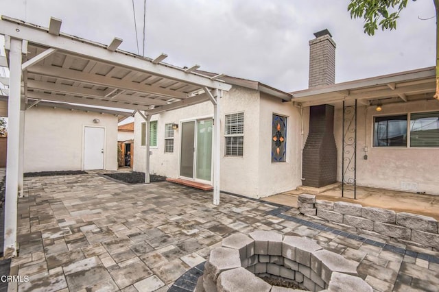 back of property with a patio area and a fire pit