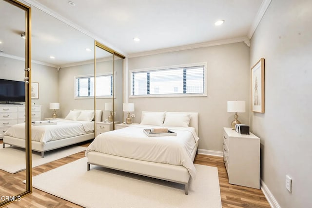 bedroom featuring wood-type flooring, ornamental molding, and a closet