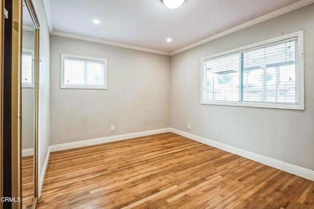 empty room with light hardwood / wood-style flooring and ornamental molding