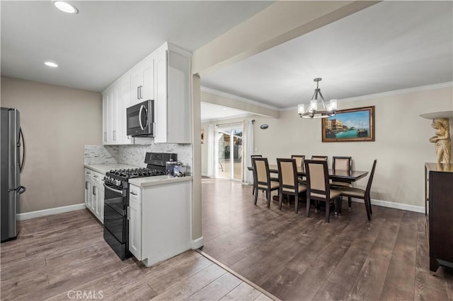 kitchen featuring stainless steel refrigerator, white cabinetry, backsplash, dark hardwood / wood-style flooring, and black range with gas stovetop