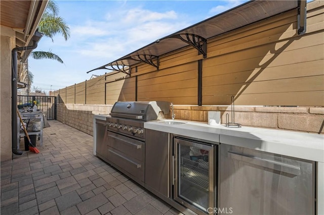 view of patio / terrace featuring wine cooler, grilling area, and exterior kitchen