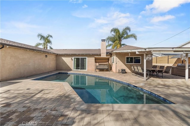 view of pool featuring area for grilling and a patio area