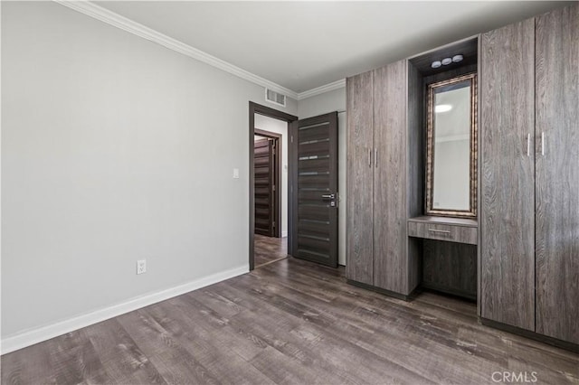 unfurnished bedroom featuring dark wood-type flooring and ornamental molding