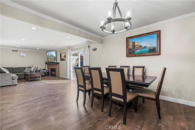 dining room featuring ornamental molding, an inviting chandelier, and dark hardwood / wood-style flooring