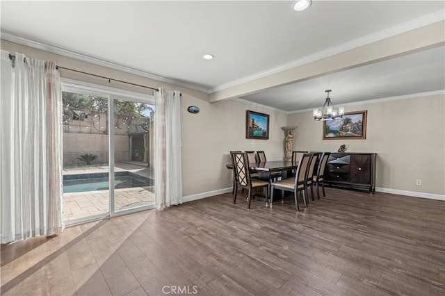 dining room featuring crown molding, wood-type flooring, and an inviting chandelier