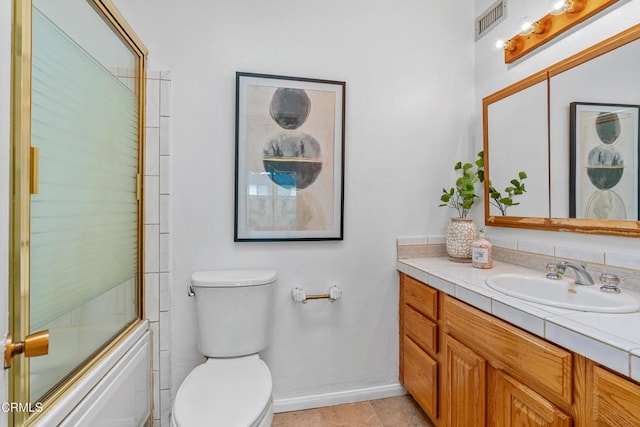 full bathroom with shower / bath combination with glass door, vanity, toilet, and tile patterned flooring