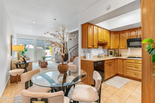 kitchen featuring sink, light tile patterned floors, and black appliances