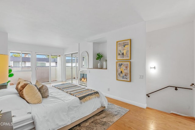 bedroom with access to exterior and light hardwood / wood-style flooring