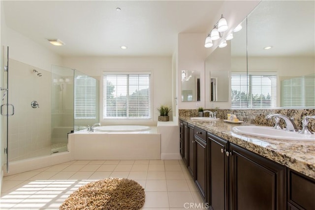 bathroom with a healthy amount of sunlight, plus walk in shower, tile patterned flooring, and vanity