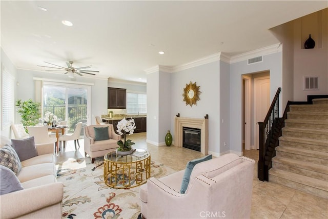 living room with ceiling fan, ornamental molding, and light tile patterned floors