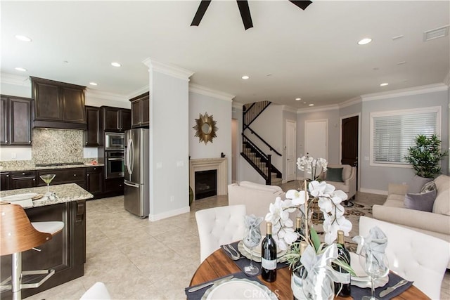 interior space with light tile patterned floors, ornamental molding, and ceiling fan