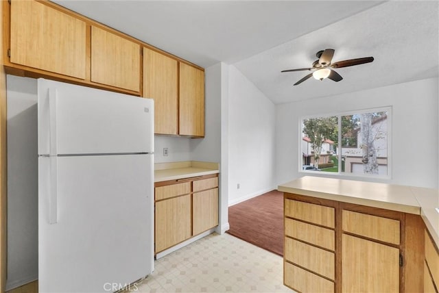 kitchen with white refrigerator, ceiling fan, lofted ceiling, and light brown cabinetry