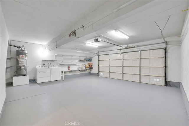 garage featuring separate washer and dryer, a garage door opener, and gas water heater