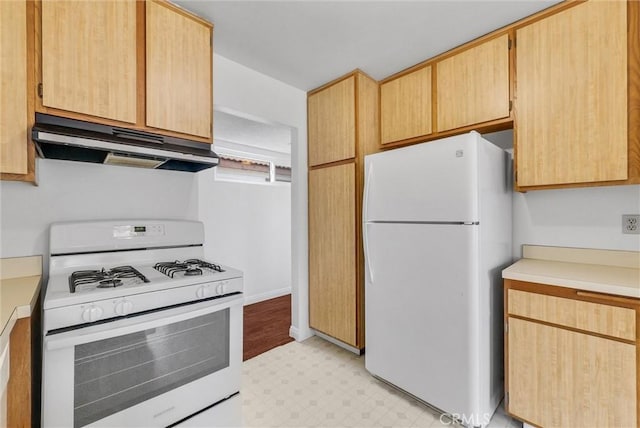 kitchen with light brown cabinetry and white appliances