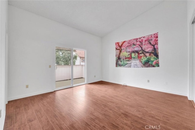 empty room featuring lofted ceiling and hardwood / wood-style floors