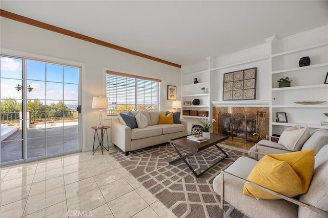 tiled living room with crown molding, a fireplace, and built in shelves