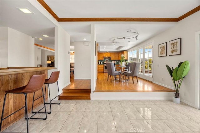 dining area featuring light tile patterned flooring and ornamental molding