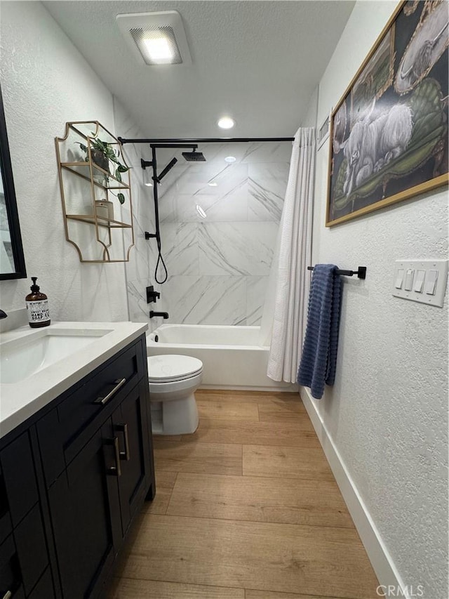 full bathroom featuring shower / tub combo, hardwood / wood-style floors, vanity, a textured ceiling, and toilet