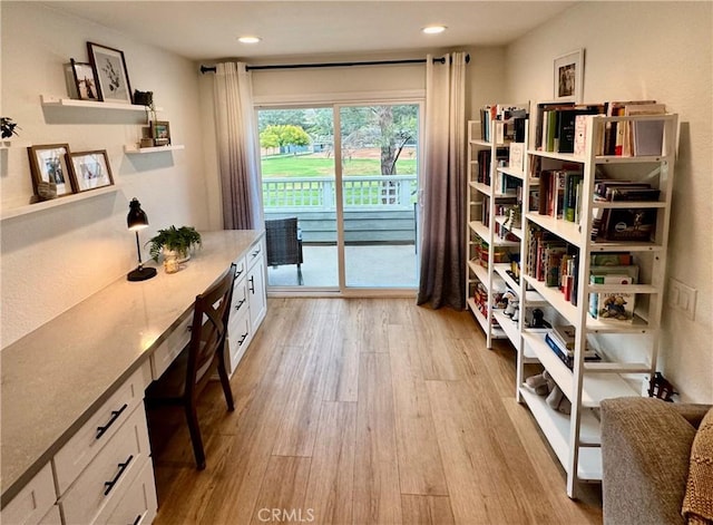 interior space featuring built in desk and light hardwood / wood-style flooring