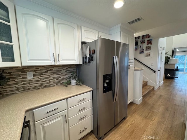 kitchen featuring white cabinetry, light hardwood / wood-style floors, stainless steel fridge with ice dispenser, and decorative backsplash