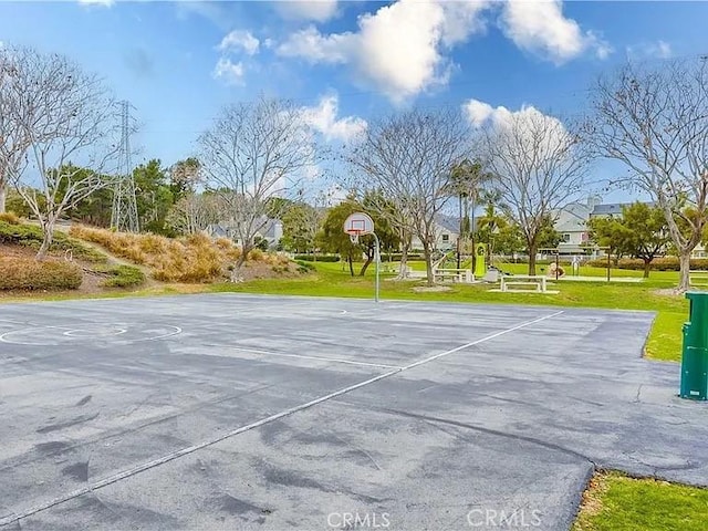 view of sport court with a lawn