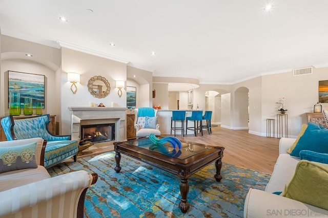 living room featuring crown molding and light hardwood / wood-style flooring