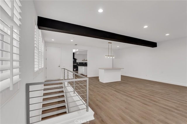 unfurnished living room with beamed ceiling and hardwood / wood-style flooring