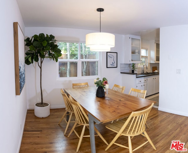 dining space featuring wood-type flooring and sink