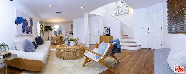 living room with hardwood / wood-style flooring and an inviting chandelier