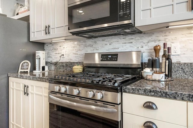 kitchen featuring white cabinets, appliances with stainless steel finishes, dark stone counters, and backsplash