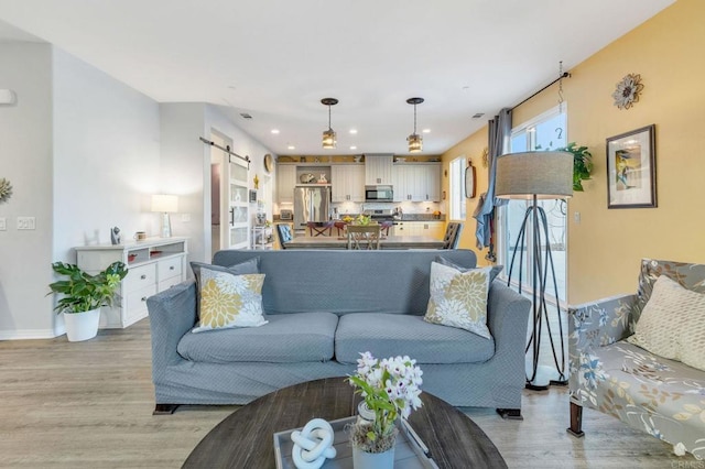 living room featuring a barn door and light hardwood / wood-style floors