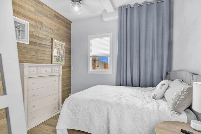 bedroom with wooden walls and light wood-type flooring