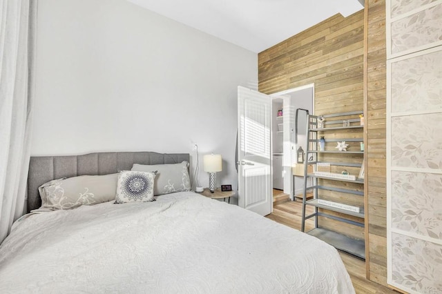 bedroom featuring wood-type flooring and wood walls