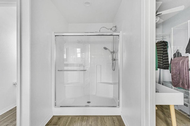 bathroom with a shower with door and hardwood / wood-style floors