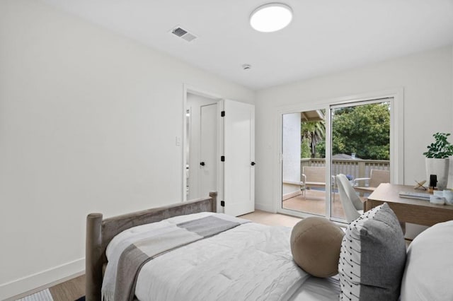 bedroom with light wood-type flooring and access to outside