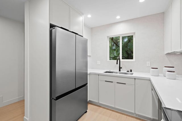 kitchen with stainless steel appliances, sink, and white cabinets