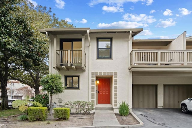 view of property with a balcony and a garage