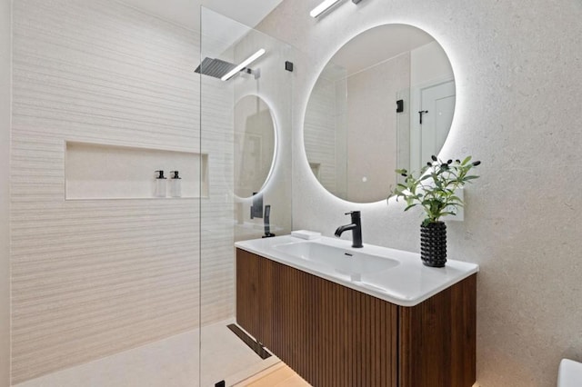 bathroom with vanity and tiled shower