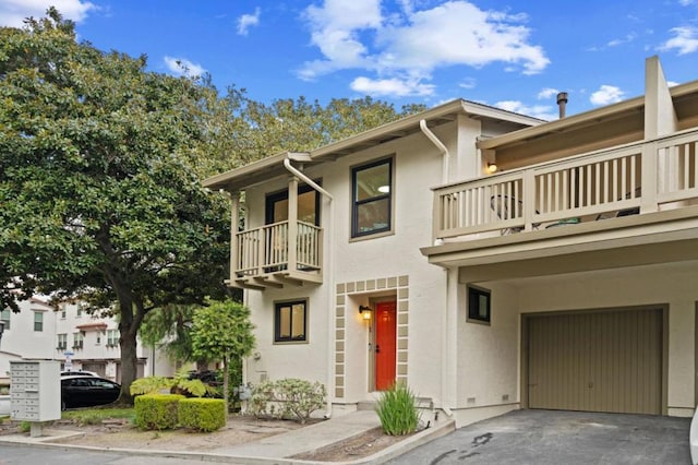 townhome / multi-family property with a balcony and a garage