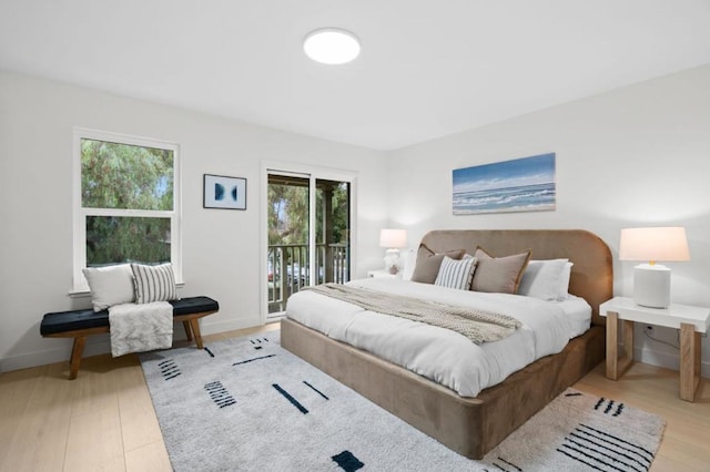 bedroom featuring light wood-type flooring and access to outside