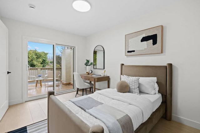 bedroom with access to exterior and light wood-type flooring