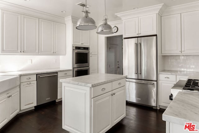 kitchen featuring white cabinetry, dark hardwood / wood-style floors, a kitchen island, pendant lighting, and stainless steel appliances