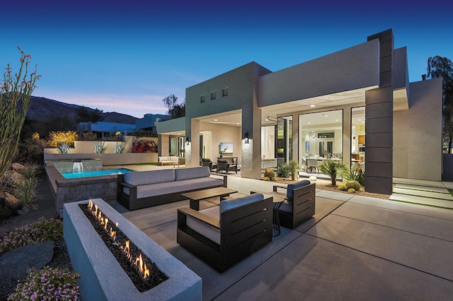 patio terrace at dusk featuring an outdoor living space with a fire pit