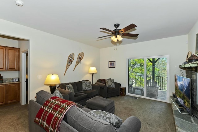 living room featuring dark colored carpet and ceiling fan