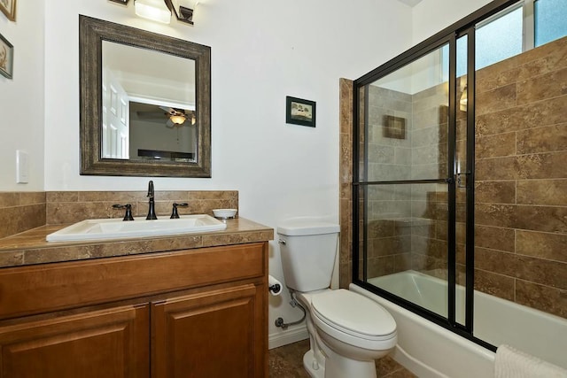 full bathroom with vanity, bath / shower combo with glass door, and toilet