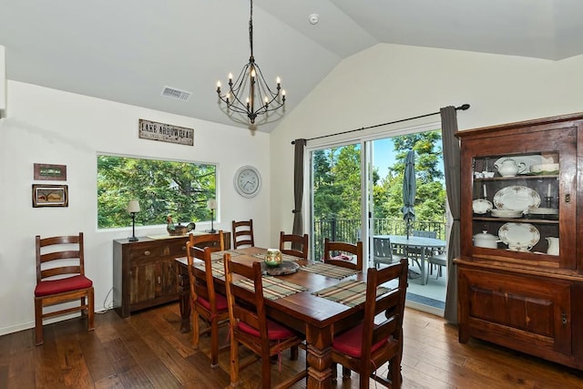 dining area featuring lofted ceiling, a chandelier, and dark hardwood / wood-style flooring