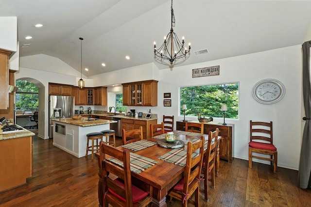 dining space featuring a healthy amount of sunlight, lofted ceiling, sink, and dark wood-type flooring