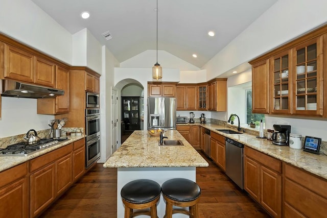 kitchen with sink, a breakfast bar area, dark hardwood / wood-style flooring, stainless steel appliances, and a kitchen island with sink